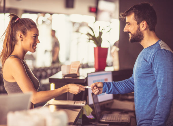 Une femme renouvelle son abonnement à la réception d'un centre sportif
